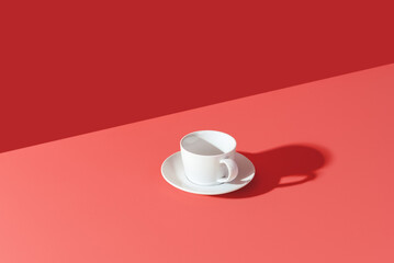 White cup in bright light isolated on a pink background