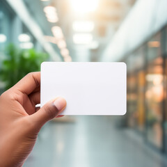 Close up of hand holding blank white business card mockup on blurred office background