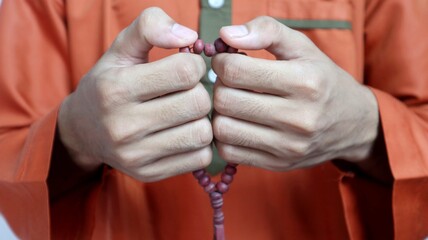 Asian Muslim man is holding prayer beads