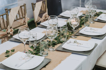 Elegant table setting for a dinner with cups, plates and flowers in a reception