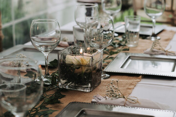 Elegant table setting for a dinner with cups, plates and flowers in a reception