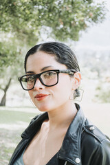 Close portrait of a white beautiful latin american woman with glasses smiling to the camera