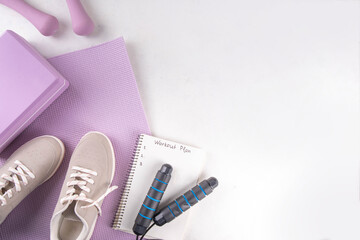 Sport and fitness, home workout plan background. Spring weight loss, slimming concept. Yoga mat and brick, dumbbells, bottle of water, headphones for sports music flat lay copy space top view