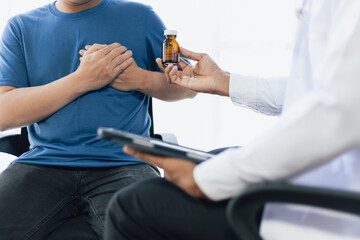 Man with chest pain consulting doctor at hospital, The doctor recommended medication for chest...