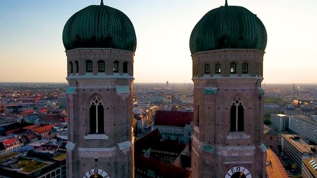 Munich frauenkirche church aerial skyline view fly over munich old town marienplatz cathedral at sunset.