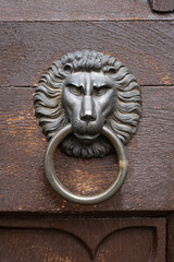 A door handle in the shape of a lion's head with an Ancient Knocker ring on an antique painted...