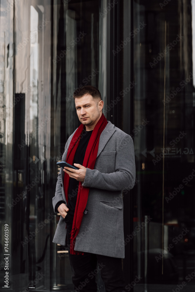 Canvas Prints a handsome man in a gray coat is walking on the street. businessman talking on the phone