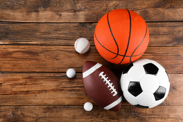 Many different sports balls on wooden background, flat lay. Space for text