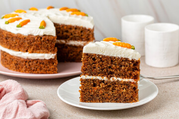 A piece of  homemade carrot cake made with walnuts, iced with cream cheese. Sweet dessert. Close-up.
