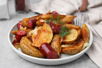 Delicious baked potato with thin dry smoked sausages, onion and dill on gray table, closeup