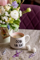 a beautiful delicate spring white and pink bouquet of tulips, buttercups and muscari. floral arrangement with coffee mug, festive morning	
