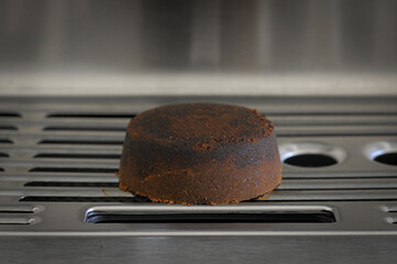 Dry coffee puck espresso puck on the tray of espresso machine