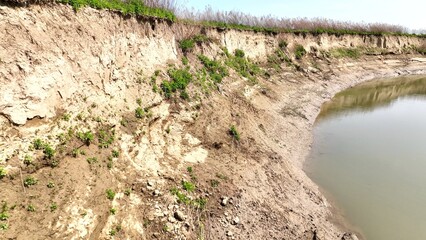 Natural erosion beside peaceful river in New York State with sunshine and blue sky during springtime