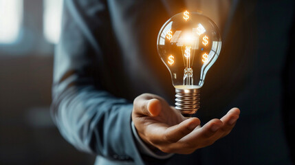 Businessman Holding Glowing Light Bulb with Financial Symbols Inside