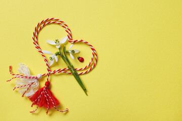 Heart made of red and white cord, snowdrop flowers on a yellow background, symbol of the holiday Martenitsa March 1, Martisor, Baba Marta, copy space - 746617590
