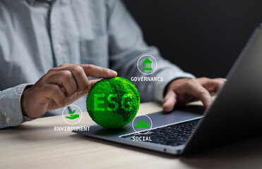 Environmental social and governance concept ESG sustainable corporate development, businessman's hand touching ESG green globe to plan investment with green business or clean energy