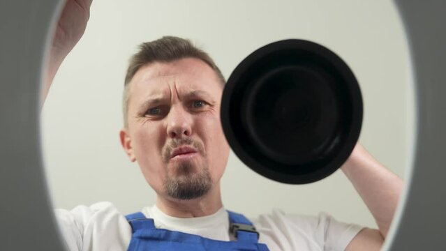 Male plumber using plunger and cleaning toilet in bathroom, close-up. 4k