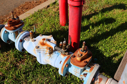 Close-up view of backflow preventers beside PIV and Pillar fire hydrant at a street corner. Fire sprinkler backflow testing, or inspection. Safety Equipment in Emergency.. Danger Prevention.