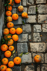 Bright orange mandarins spilled across ancient weathered grey cobblestones in old town plaza in the Mediterranean.