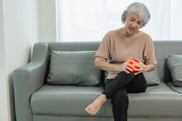 Elderly Asian woman has osteoarthritis pain at her home, has chronic knee pain from rheumatoid arthritis and walks in pain: Health care for elderly osteoarthritis.