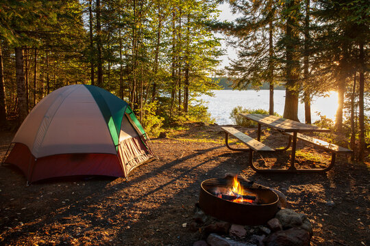 Campsite on lake in northern Minnesota with campfire at sunset