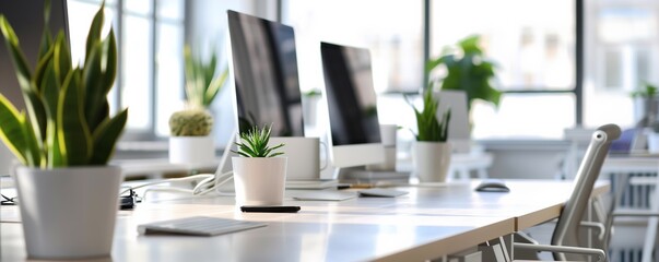 Fototapeta premium Modern Office Workspace with Desktop Computers and Indoor Plants for Biophilic Corporate Interior Design
