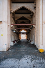 Fototapeta na wymiar Doha, Qatar - February 8, 2024: Entrance to the Bird Market in Souq Waqif with benches on both sides and the ground is wet in Doha, Qatar