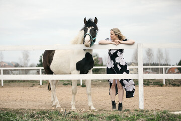 portrait of a young woman with a horse. They stand together on the ranch, in nature. They are happy and free.