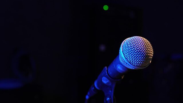 Studio Condenser Microphone Isolated in Black Color, Studio Microphone in Empty Recording Studio with Copy Space, in Neon Blue Light.