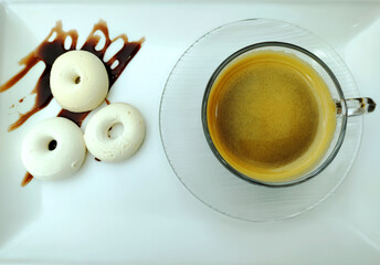 Cappuccino in the glass mug and brazilian traditional cream doughnut with sophisticated presentation