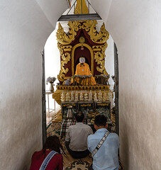 Burmese on the ground praying to their Buddha