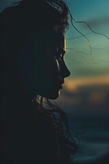 Naklejka premium A silhouette of a woman with her hair blowing in the wind. Perfect for fashion or beauty concepts