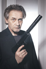 Old member of criminal  gang in alert ready to shoot in hotel room
