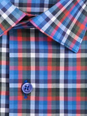 Close-up of a button placket on a multi-colored plaid men's shirt