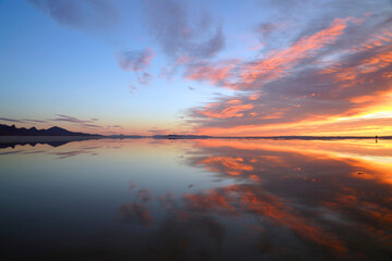 Colorful sunrise at Bonneville Salt Flats with spectacular water reflection near Wendover in Utah,...