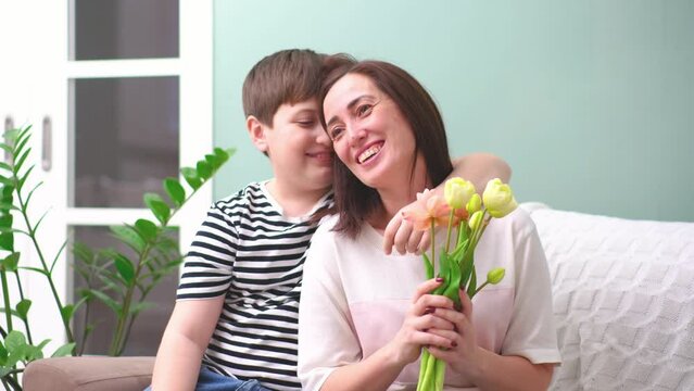 Happy little boy hugging his mother at home. Loving mum and kid cuddling embrace cheerful to family holiday event.Concept love mom.