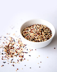 Organic Tri-Color Quinoa in a White Ceramic Bowl. Healthy Eating Concept.