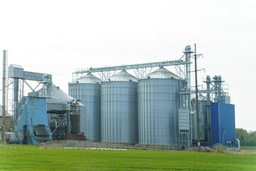 Modern Grain Silos And Storage Buildings On A Rural Farmland During Springtime