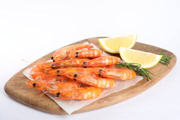 Delicious cooked shrimps served with lemon and rosemary on white background