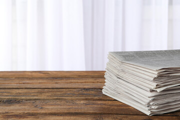 Stack of newspapers on wooden table, space for text. Journalist's work - obrazy, fototapety, plakaty