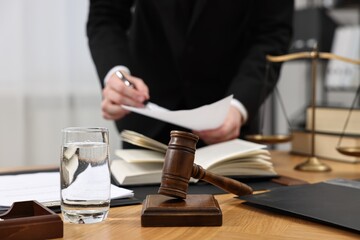 Lawyer working with document at wooden table, closeup