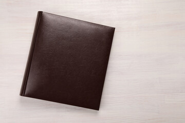 One photo album on wooden table, top view. Space for text