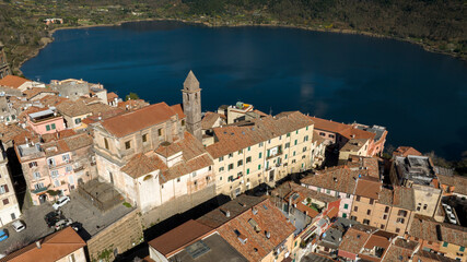 Naklejka premium Aerial view of the church of Santa Maria della Cima. It is a Catholic church in Genzano di Roma, in the metropolitan city of Rome, Italy. In the background the lake of Nemi. 