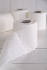 Soft toilet paper rolls on white wooden table