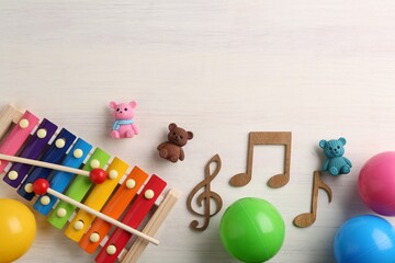 Baby song concept. Wooden notes, xylophone and toys on table, flat lay. Space for text
