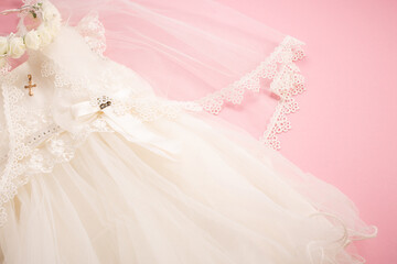 Baby baptism dress on pink background with cross and crown