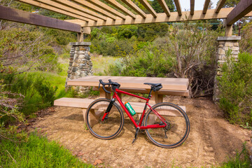 Gravel bike resting in a Topanga Picnic Area with stacked stone columns and a slatted wood roof.