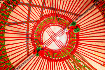 Yurt interior. Shanyrak impotant element of traditional Kyrgyz tent. Tunduk symbol in center of Kyrgyzstan national flag. National decoration on roof Embroidery and patterns of nomads central Asia. - obrazy, fototapety, plakaty