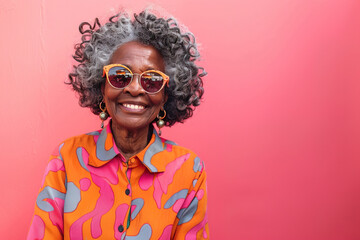 Front view of senior hipster Afro American woman with modern clothes and sunglasses over colorful pink background with copy space - obrazy, fototapety, plakaty