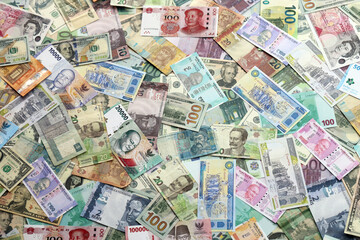 Fototapeta na wymiar Many banknotes of different currency. Background of big amount of random money bills close up